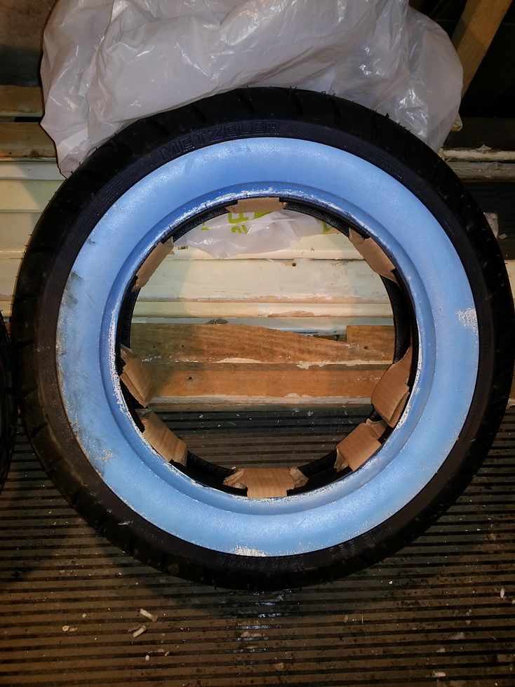 Заднее колесо, будет с белой полосой сбоку, которая для транспотировки покрыта синей зажитной плёнкой.